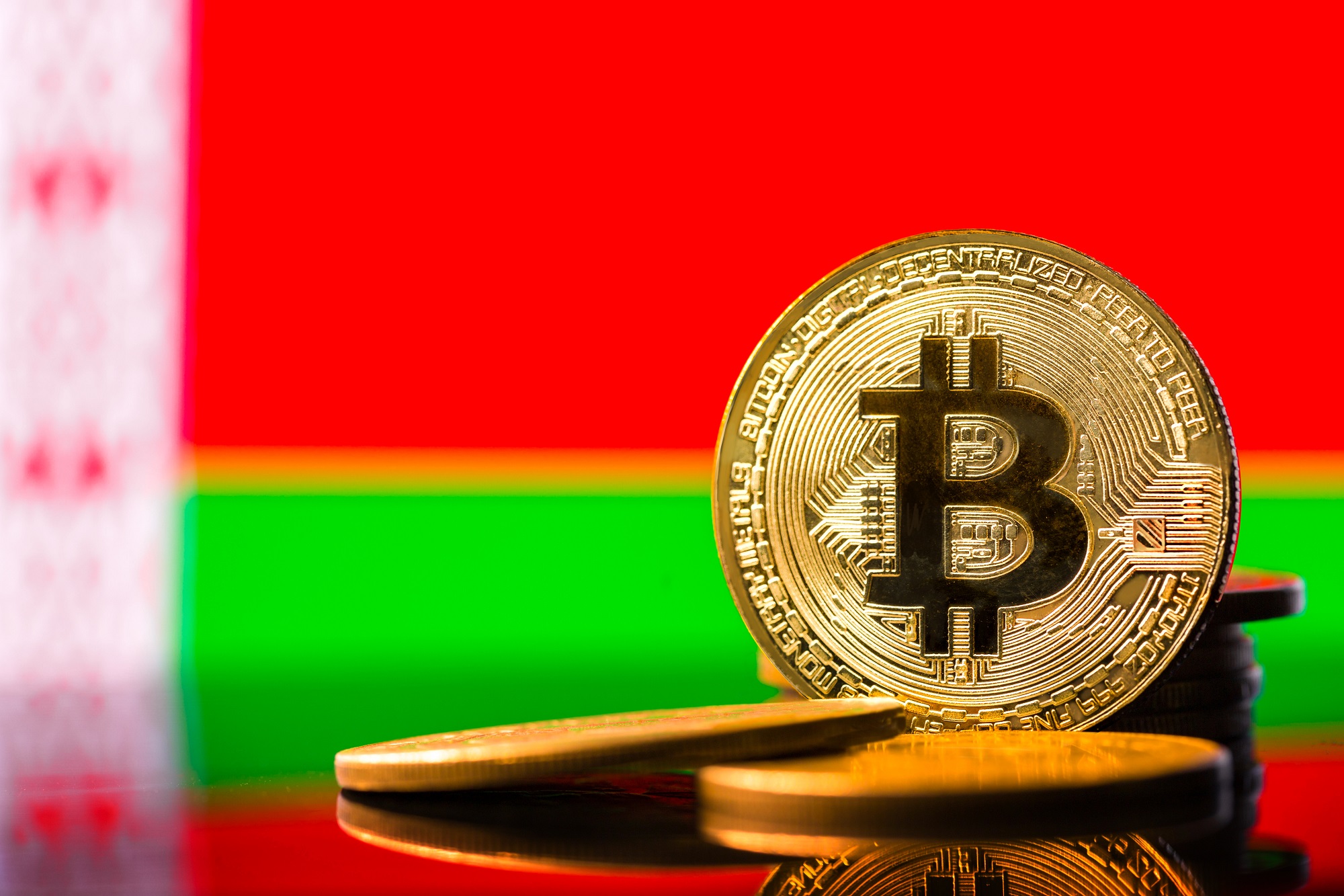 在白俄羅斯國旗背景下代表比特幣的代幣。