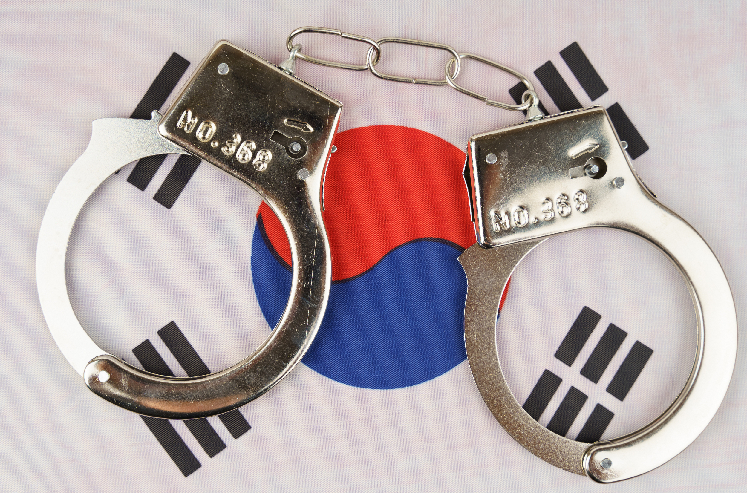 一副手銬放在韓國國旗上。