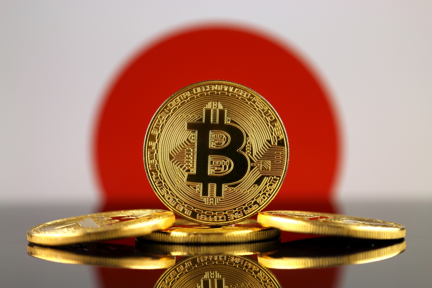 五種金屬代幣旨在代表日本國旗背景下的比特幣。